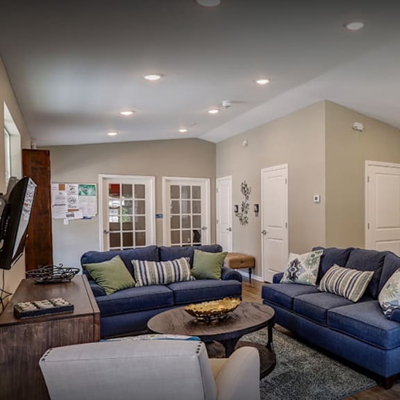 a living room and kitchen with couches and a table