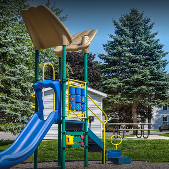 a playground with a slide and a picnic table