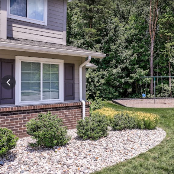 a yard with a swing set in front of a house