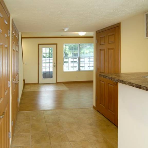 an empty kitchen and living room with a door to a patio