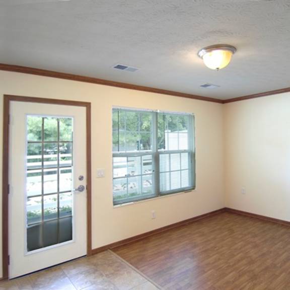 an empty living room with a door and a window