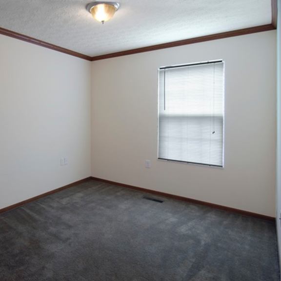 an empty room with a window and a carpet