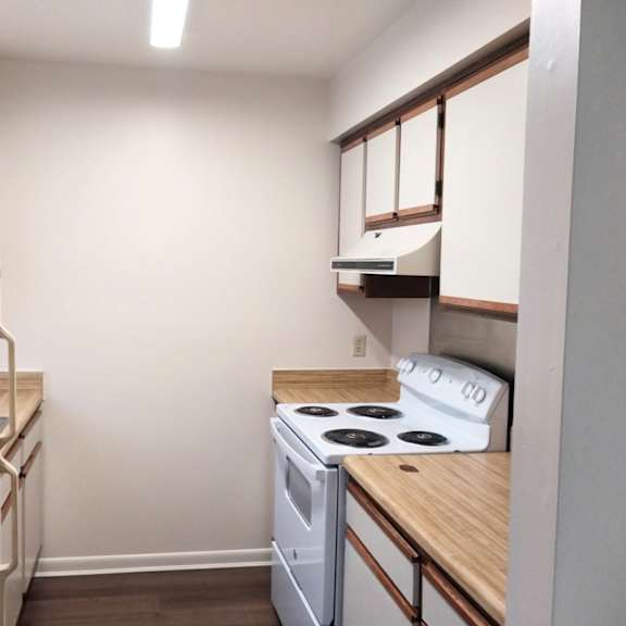 a small kitchen with a white stove and refrigerator.