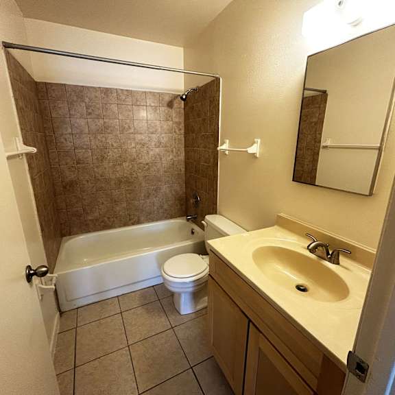 a bathroom with a white tub, sink, and toilet.