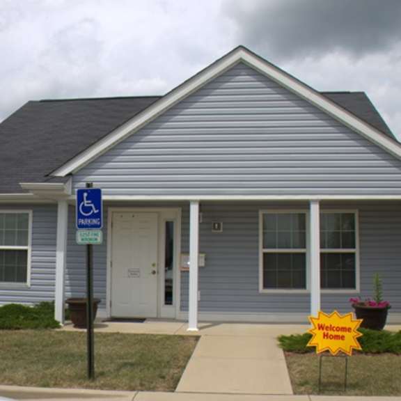 a blue house with a handicapped sign in front of it
