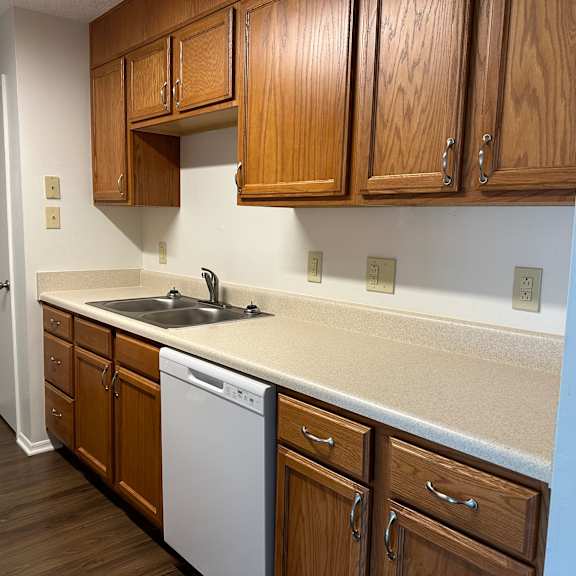 an empty kitchen with wooden cabinets and a sink