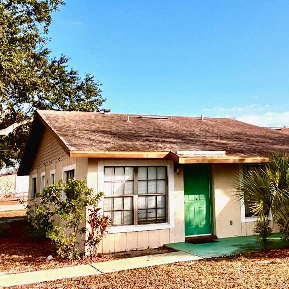 a house with a green door and a brown roof.