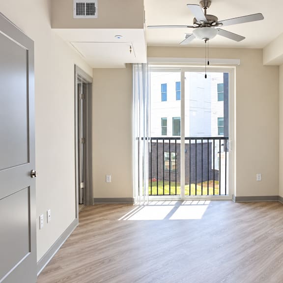 a room with a sliding glass door leading to a balcony.