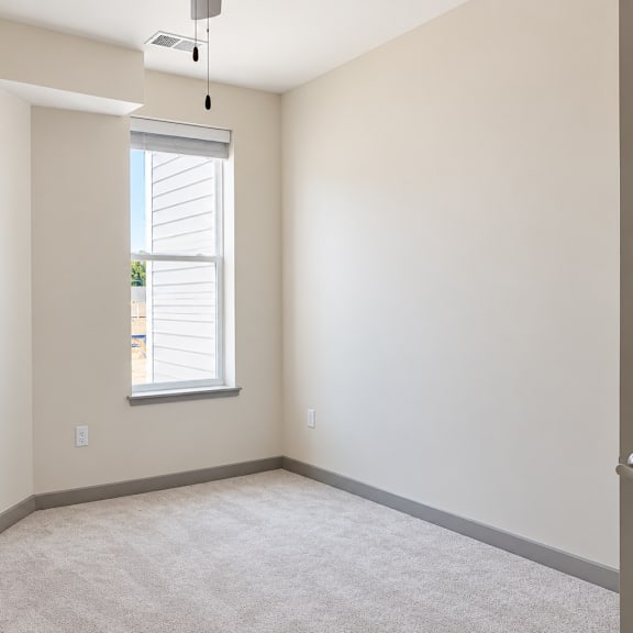 a room with a window and carpeted floor.