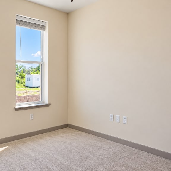 a room with two windows and a view of a field.