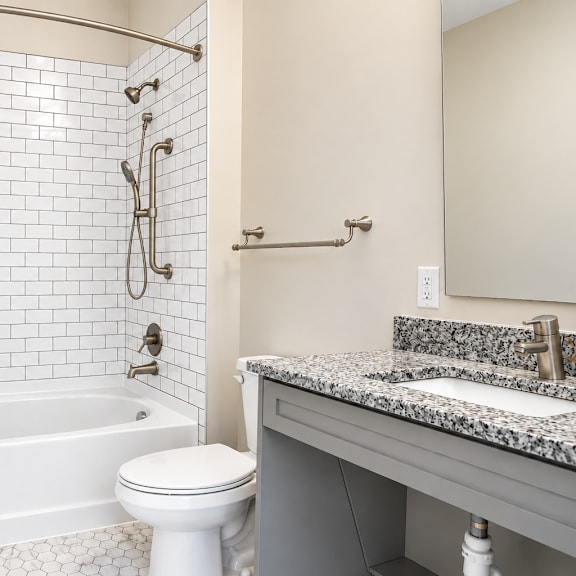 a white tiled bathroom with a tub, toilet, and sink.
