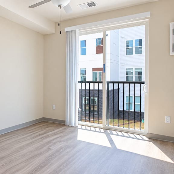 a room with a sliding glass door leading to a balcony.