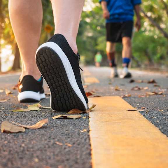 a person is walking on a road with a yellow line.