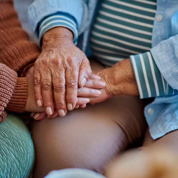 two hands clasped together in the center of a group of people.