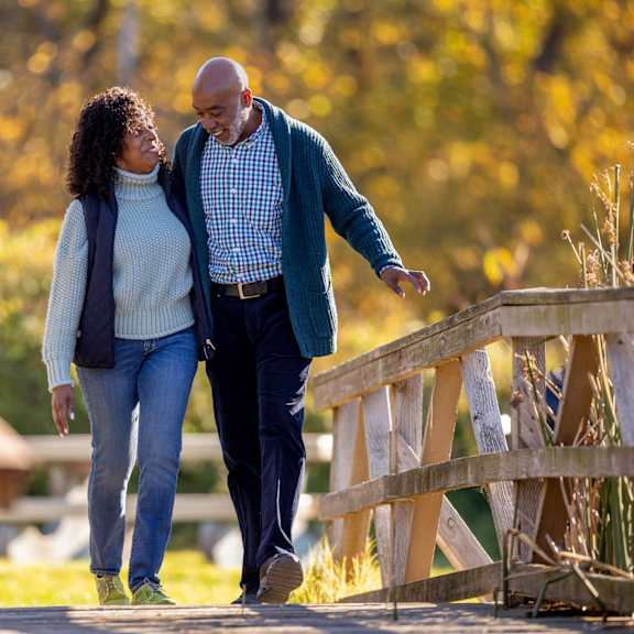 a man and a woman are walking on a bridge.