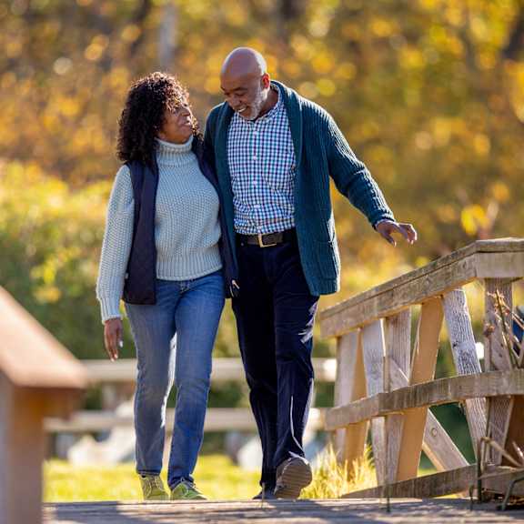 a man and a woman are walking on a bridge.