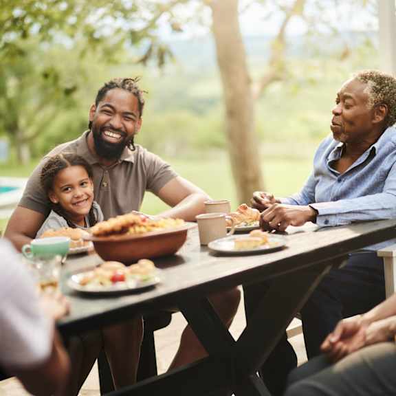 a family enjoying a meal together outdoors.