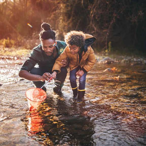 two people are fishing in a river.