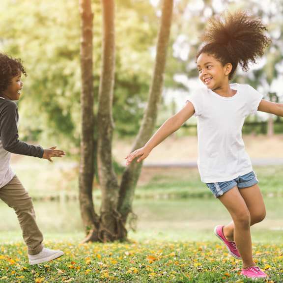 a group of young girls running in a park