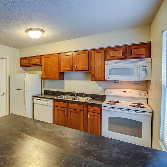 a kitchen with white appliances and wooden cabinets