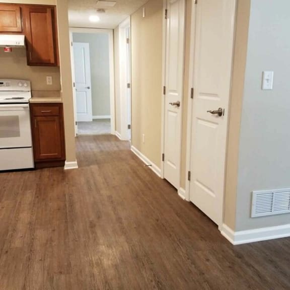 a kitchen and a living room with a wood floor