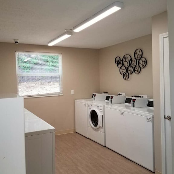 a laundry room with two washing machines and a window