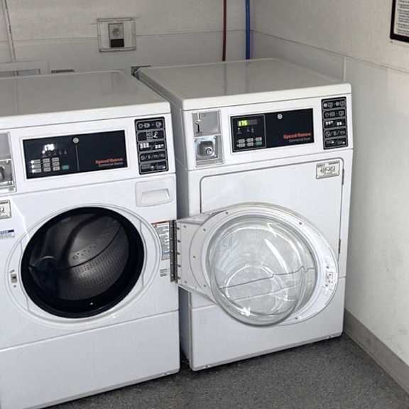 two washing machines sitting next to each other in a laundromat