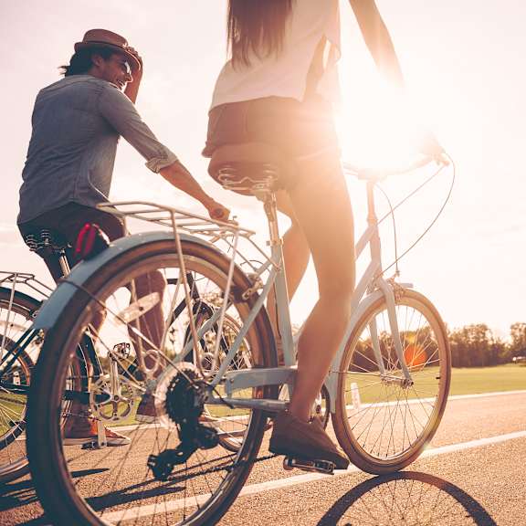 a man and a woman riding a bike down a street