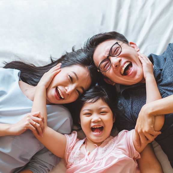 a woman and two children laying on a bed