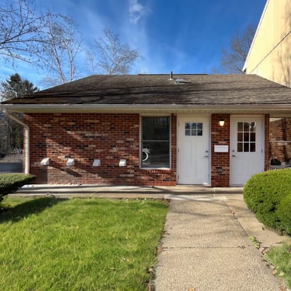 a small brick house with a white door