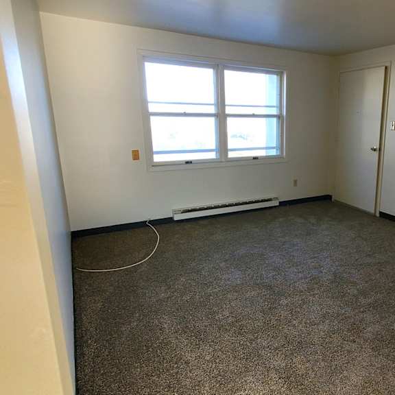 an empty room with a window and a door