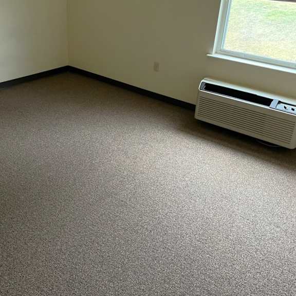 an empty room with a heater and a window