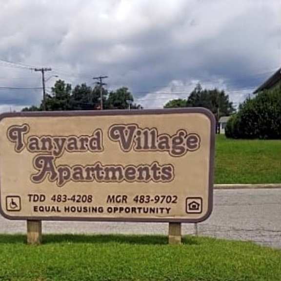 a sign in the grass that says taylor village apartments