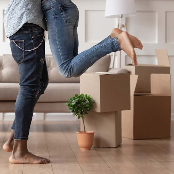 a woman with cardboard boxes in a living room