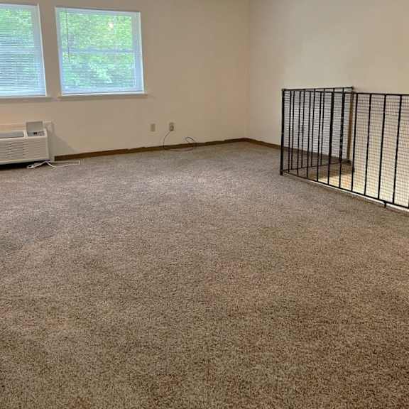an empty room with a cage and a window