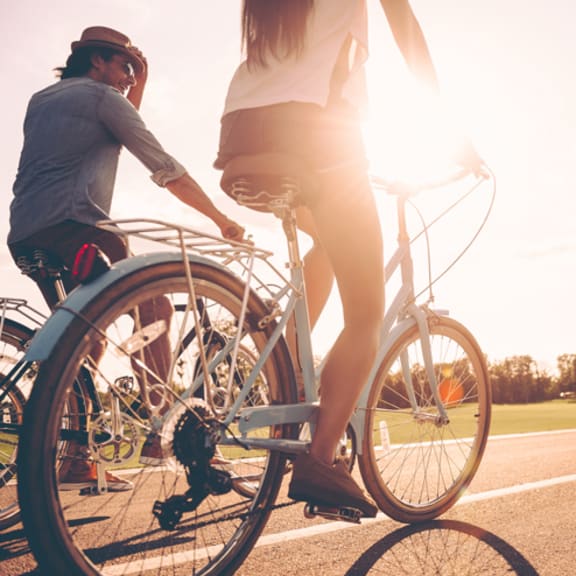 a man and a woman riding a bike down a street