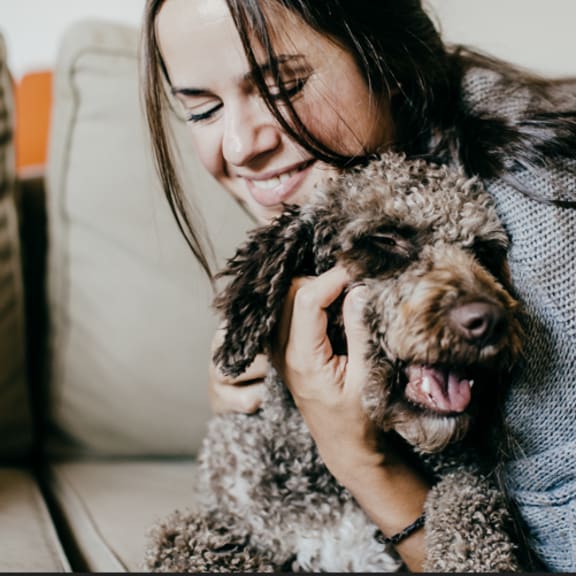 a woman sitting on a couch with a dog