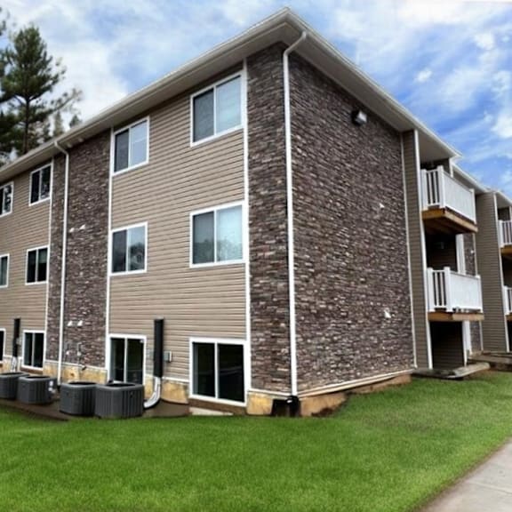 a large apartment building with a stone facade and multiple balconies.