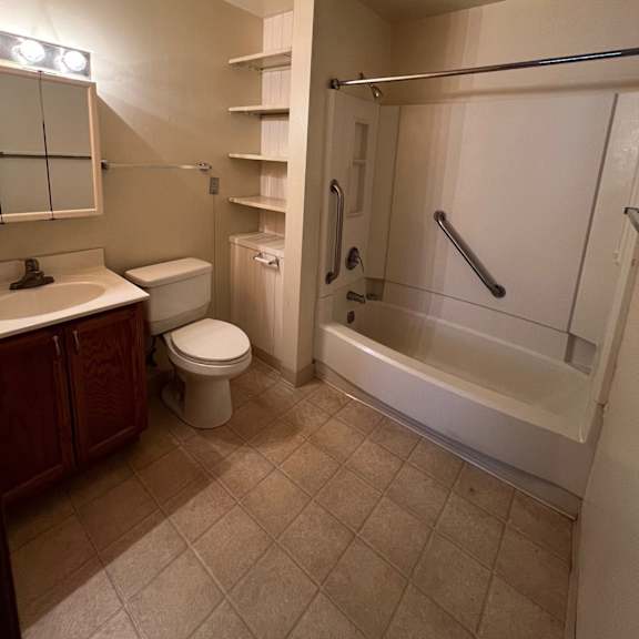 a bathroom with a toilet, sink, and bathtub.
