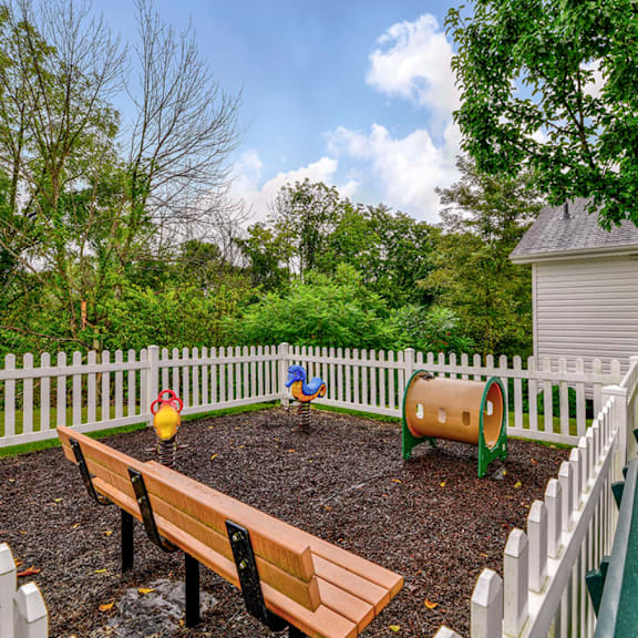 a fenced in backyard with a garden and benches