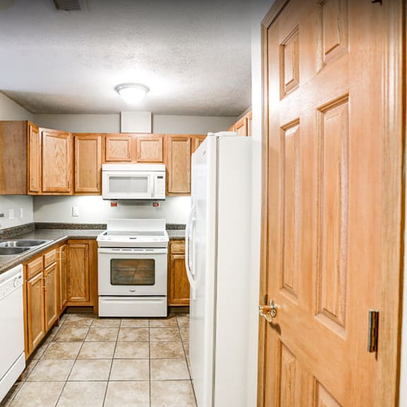 a kitchen with wooden cabinets and white appliances