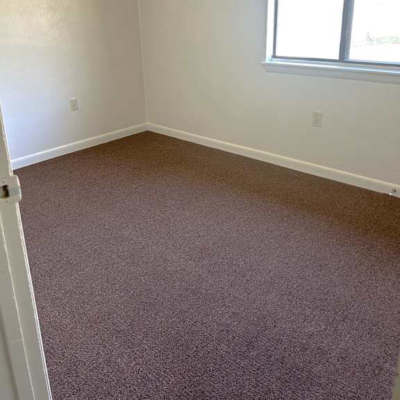 a room with a carpeted floor and a window