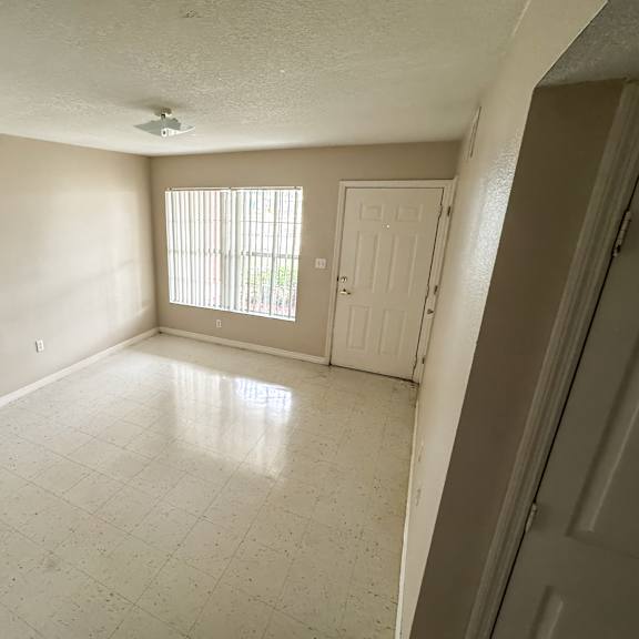 a room with a tiled floor and a window with blinds.