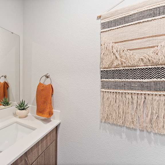 Thumbnail 7 of 24 A bathroom with a white sink and a mirror.