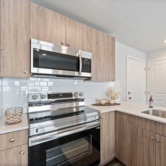Thumbnail 6 of 24 A modern kitchen with wooden cabinets and stainless steel appliances.