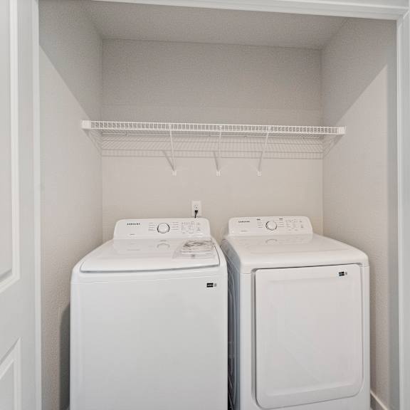 Thumbnail 11 of 24 Two white front loading washing machines in a small laundry room.