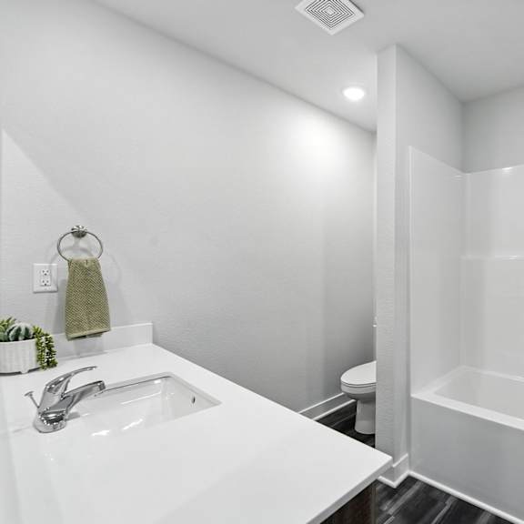 Thumbnail 22 of 23 A white bathroom with a sink, toilet, and bathtub.