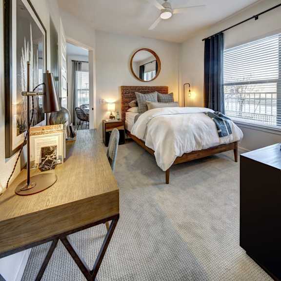 a bedroom with a large bed and a wooden table.