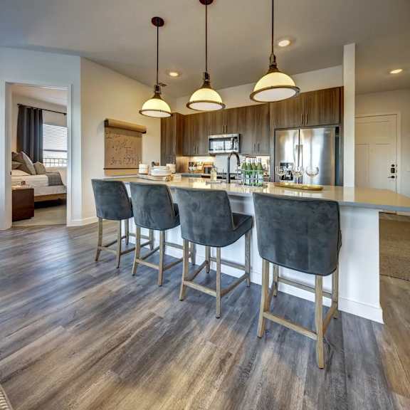 a kitchen with a bar area featuring a long counter and bar stools.