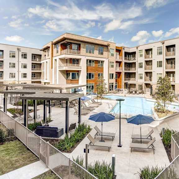 a large apartment complex with a pool and patio area.